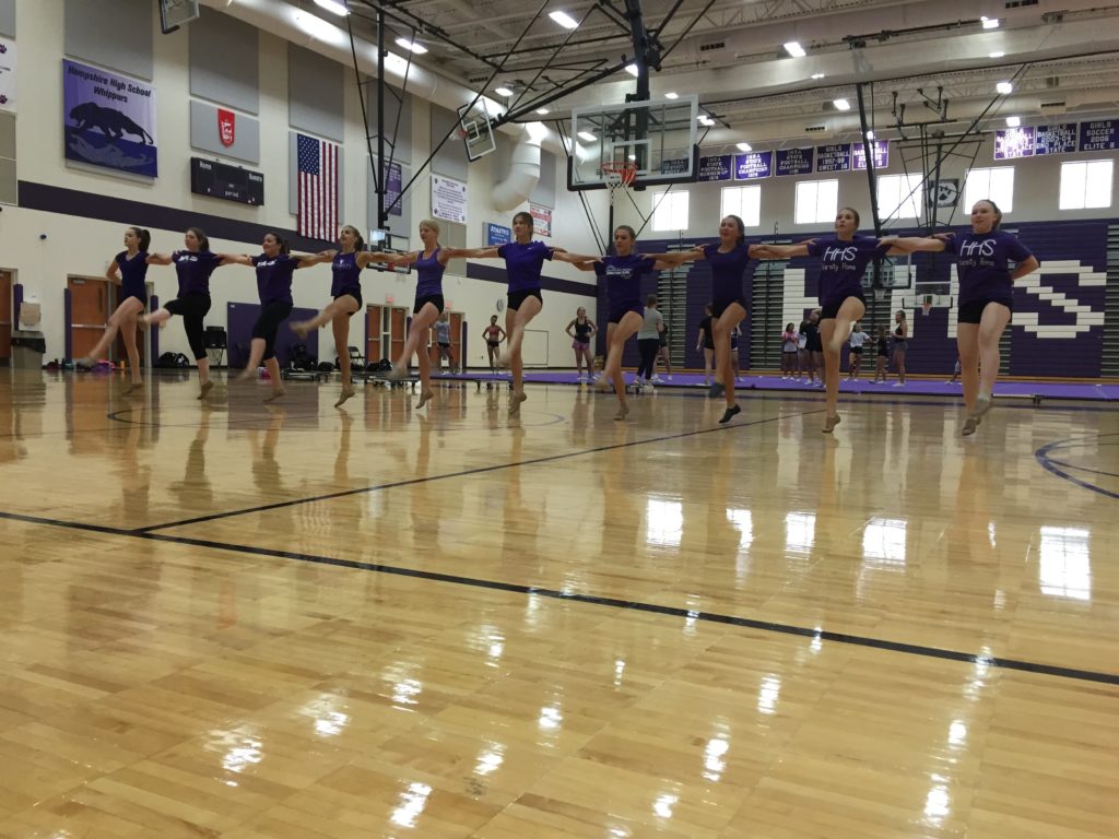 Hampshire practicing kicks and splitting the gym with cheer