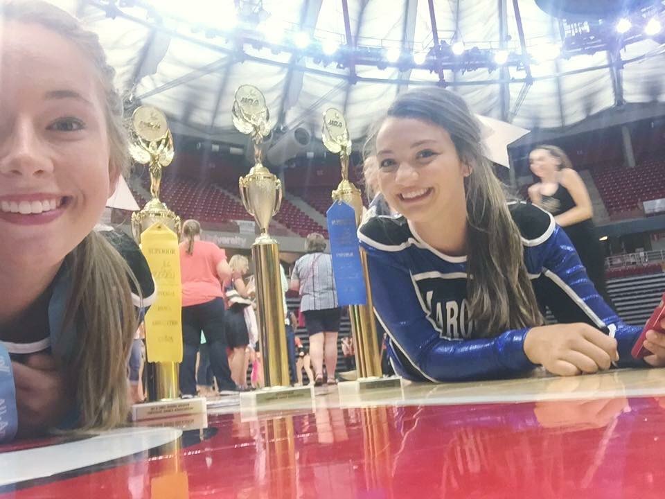 A couple Marquette dancers making their UDA trophies look gigantic